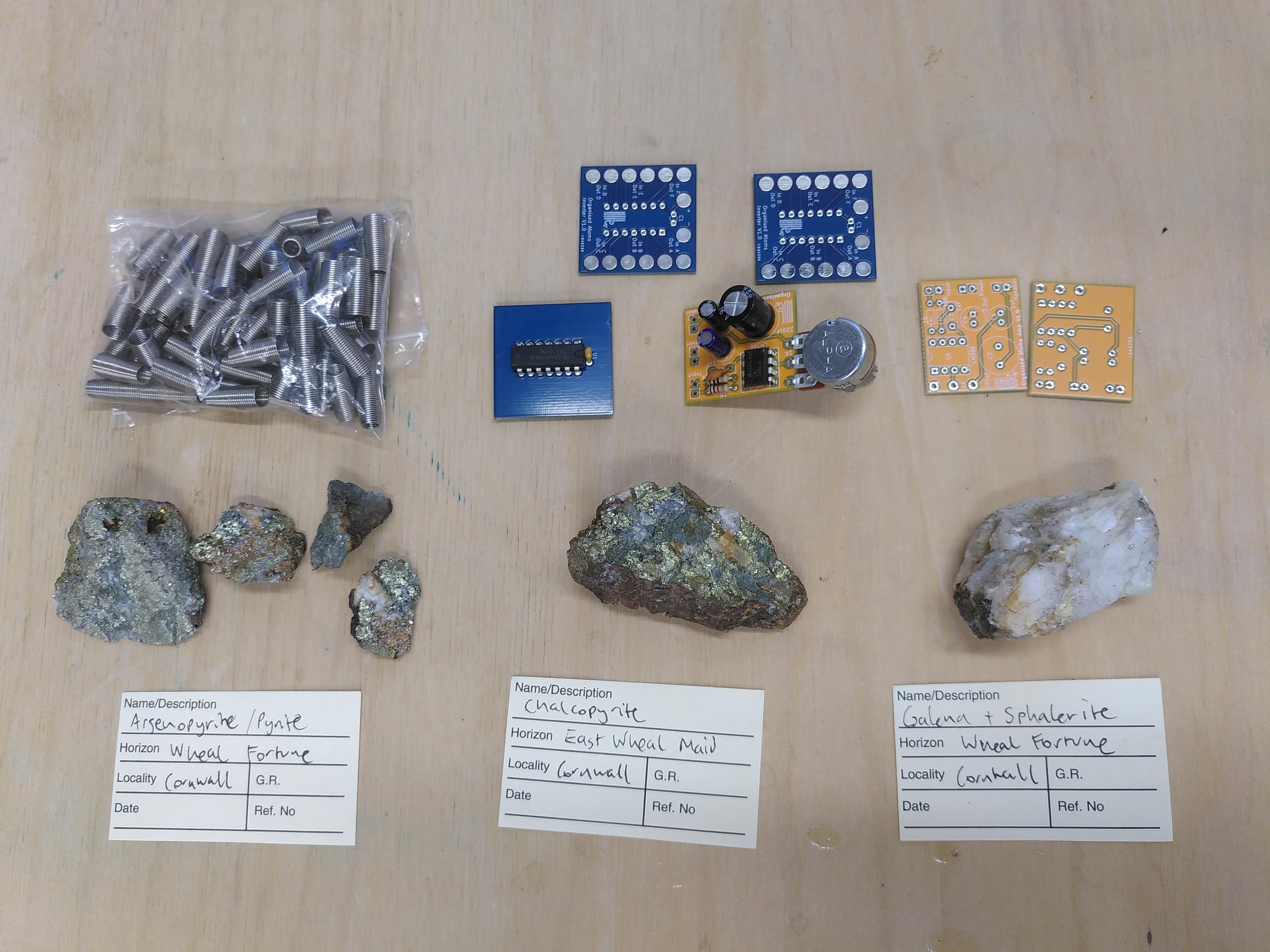 A bag of springs, 6 circuit boards, 2 populated with components and 6 geological specimens of semiconducting minerals from mine sites in Cornwall, asenopyrite, chalcopyrite and galena (with sphalerite).